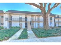 Two-story building with manicured landscaping and a large tree in front at 809 Russell Ln # 323, Brandon, FL 33510