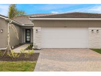 Modern home exterior with two-car garage and landscaped walkway at 12355 Hearts Ease St, Venice, FL 34293