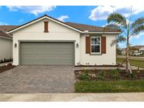 Single-story home with a gray garage door and landscaped yard at 12310 Hearts Ease St, Venice, FL 34293