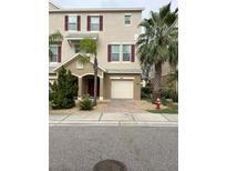 Two-story townhome with red door, attached garage, and landscaping at 844 Callista Cay Loop, Tarpon Springs, FL 34689