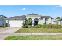 One-story home with attached garage, manicured lawn, and lush landscaping at 510 Tuscanny St, Brandon, FL 33511