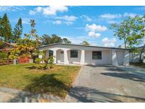 Newly renovated home with white exterior, landscaping, and driveway at 6318 S Renellie Ct, Tampa, FL 33616