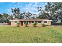 Brick ranch home with a large front yard and mature trees at 1406 E Spencer St, Plant City, FL 33563