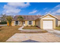 Tan brick ranch home with attached garage and small front yard at 1930 Castle Bay Ct, Oldsmar, FL 34677