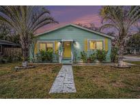 Charming light green house with yellow shutters, walkway, and landscaping at 1701 32Nd N Ave, St Petersburg, FL 33713
