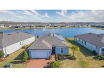 Aerial view of a single-Gathering home with solar panels and a lake view at 19494 Sea Glass Cir, Land O Lakes, FL 34638