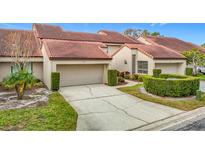 Tan two-story home with a two-car garage and manicured landscaping at 3076 Braeloch E Cir # 5, Clearwater, FL 33761