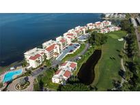 Stunning aerial view of waterfront condos with red tile roofs, golf course, and community pool at 5642 Puerta Del Sol S Blvd # 242, St Petersburg, FL 33715