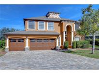 Two-story house with a three-car garage and paver driveway at 13181 Linzia Ln, Spring Hill, FL 34609