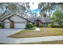Brick house with three-car garage, mature landscaping, and a large front yard at 807 Belle Timbre Ave, Brandon, FL 33511
