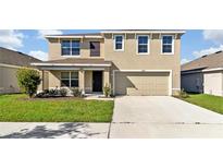 Two-story house with a two-car garage and a well-manicured lawn at 16743 Carlton Pond St, Wimauma, FL 33598