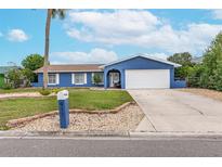 Blue house with white trim, a two-car garage, and a well-manicured lawn at 911 Silver Palm Way, Apollo Beach, FL 33572