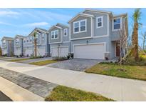 Row of charming townhouses with attached garages and paved driveways at 31472 Woodland Race Loop, Wesley Chapel, FL 33545