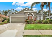 Attractive single-story house with a two-car garage and well-manicured lawn at 22247 Red Jacket Ln, Land O Lakes, FL 34639