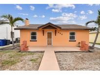 Orange house with a walkway, landscaping, and a detached garage at 440 77Th Ave, St Pete Beach, FL 33706