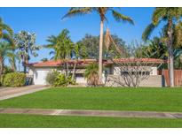 Single story home with red tile roof, lush landscaping, and a large grassy yard at 587 Hillcrest Dr, Largo, FL 33771