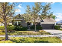Gray Craftsman style home with landscaping, two-car garage, and large front yard at 6650 Current Dr, Apollo Beach, FL 33572