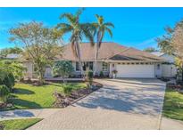 Beautiful home with landscaped yard, paver driveway, and two palm trees at 1000 Chillum Ct, Safety Harbor, FL 34695
