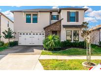 Two-story house with three-car garage, landscaping and paver driveway at 21680 Violet Periwinkle Dr, Land O Lakes, FL 34637