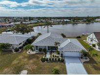 An aerial view of a home, featuring a well-manicured lawn, lakeside access, and neighborhood at 407 Blackhawk Cir, Sun City Center, FL 33573