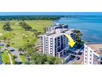 Aerial view of waterfront condo building with golf course and bay views at 6 Belleview Blvd # 105, Belleair, FL 33756