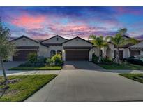 Two-story home with brown garage door and landscaping at 17554 Holly Well Ave, Wimauma, FL 33598
