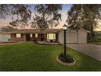 Brick ranch home with landscaped yard, and a two-car garage at 413 Belle Claire Ave, Temple Terrace, FL 33617