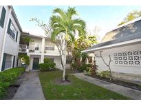 Exterior view of condo building with lush landscaping and walkways at 4315 Aegean Dr # 110C, Tampa, FL 33611
