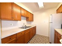 Bright kitchen features wood cabinets, white appliances, and tiled floor at 4315 Aegean Dr # 110C, Tampa, FL 33611