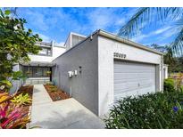 Gray townhome exterior with walkway, landscaping, and attached garage at 13635 Twin Lakes Ln # 13635, Tampa, FL 33618