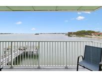 Breathtaking water view from private balcony, featuring a relaxing chair and access to a pier at 464 N Paula Dr # 322, Dunedin, FL 34698