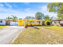 Charming yellow house with well-manicured lawn and American flag at 1010 59Th N Ave, St Petersburg, FL 33703