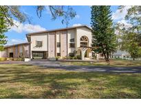 Brick and stucco home with a large yard and paved driveway at 18409 Tyler Rd, Odessa, FL 33556