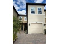 Two-story townhome with a two-car garage and a well-manicured front yard at 29955 Southwell Ln, Wesley Chapel, FL 33543