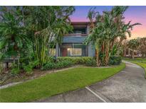 Condo building with lush landscaping and a paved walkway at 10263 Gandy N Blvd # 107, St Petersburg, FL 33702