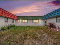 Three unit building exterior with grassy yard and colorful roofs at sunset at 1802 N Bedford Ln # 19, Sun City Center, FL 33573