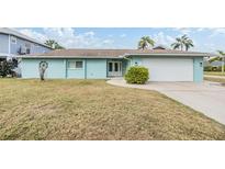 Light blue house with white garage door and well-maintained lawn at 8009 Brighton Dr, Port Richey, FL 34668