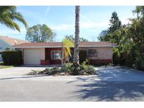 Single-story home with a spacious yard and palm trees at 215 176Th Terrace E Dr, Redington Shores, FL 33708
