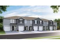 Townhouse exterior boasts a modern design with gray siding, and two-car garages at 32619 Turtle Grace Loop, Wesley Chapel, FL 33545
