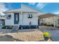 Cute Florida mobile home with carport, landscaping, and paved driveway at 4851 W Gandy Blvd # B6 L3, Tampa, FL 33611