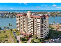 Aerial view of a waterfront condo building with a pool and parking at 700 Island Way # 704, Clearwater Beach, FL 33767