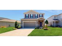 Two-story house with a neutral color scheme and a well-manicured lawn at 10827 High Noon Trl, Parrish, FL 34219