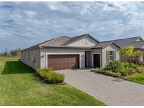 Attractive single-story home with a brown garage door and landscaped front yard at 12626 Tahitian Pearl Cir, Parrish, FL 34219