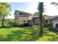 Two-story house with a tan exterior, double doors, and a landscaped lawn at 131 Mystic Lake N Dr, St Petersburg, FL 33702