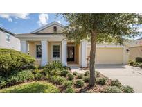 Inviting single-story home featuring manicured landscaping and a covered porch, perfect for relaxing outdoors at 1838 Tallulah Ter, Wesley Chapel, FL 33543