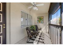 Cozy screened balcony with rocking chairs and tropical art at 2420 Winding Creek Blvd # 206, Clearwater, FL 33761