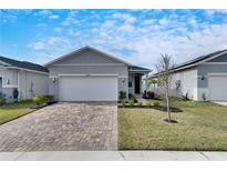 Gray house with white garage door and landscaped yard at 2584 89Th Street E Cir, Palmetto, FL 34221