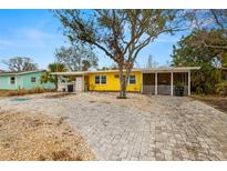 Bright yellow house with a large front yard and paved driveway at 2812 Miriam S St, Gulfport, FL 33711