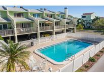 Community pool with patio and surrounding townhomes at 318 Windrush Blvd # 10, Indian Rocks Beach, FL 33785