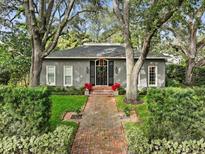 Gray house with brick walkway, lush landscaping, and mature trees at 3301 W Morrison Ave, Tampa, FL 33629